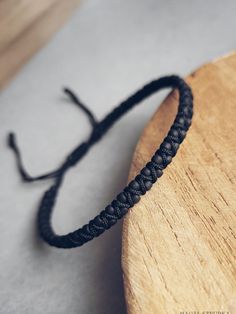 a close up of a wooden board with a black string on it's end