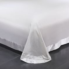 the bed is made with white sheets and pillows