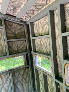 the inside of a building with several windows and grass growing on it's sides