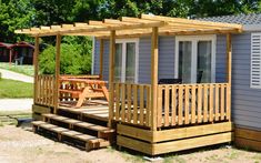 a small house with a deck and picnic table