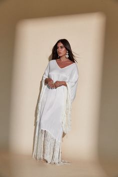 SOL FRINGE KAFTAN - OFF WHITE – Kadimah White Fringe V-neck Dress, White V-neck Dress With Fringe, Elegant White V-neck Kaftan, Vacation V-neck Kaftan With Tassel Ties, White Maxi Dress With Tassels, Elegant White Kaftan For Festival, Chic Long White Kaftan, White Fringe Maxi Dress For Vacation, Chic White Maxi Dress With Fringe