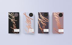 three different types of chocolates with gold foil lettering on the side and black, white, and pink packaging