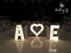 the word love spelled out in front of tables with white linens and lights on them