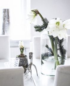 white flowers are in glass vases on a table next to other objects and decor