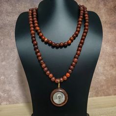 37" This Uniquely Designed Double Sided Photo Pendant Necklace Expertly Combines Wild Country Rosewood and Meditation Beads for an Elegant and Timeless Look. Handcrafted with Quality Materials, The ORIGINAL OSHO Rajneeshpuram Wild Country Rosewood Meditation Beads Mala Necklace Is the Perfect Accessory for Your Mindful Journey. ✥ Pendant size ✥ Necklace length - 37" (w/o pendant 35") ✥ Handmade by Artisans in India ❀❀❀Please look closely at photos as part of item description, the product in the Wooden Beads Amulet Necklace For Meditation, Traditional Wooden Beads Necklace For Meditation, Meditation Amulet Necklace With Wooden Beads, Traditional Wooden Bead Necklaces For Meditation, Spiritual Wooden Beads Necklace For Meditation, Wooden Beads Amulet Jewelry For Meditation, Brown Natural Stones Mala As A Gift, Meditation Amulet With Wooden Beads, Wooden Beads Amulet Necklace As A Gift