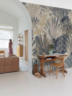 a living room with a couch, table and wallpaper on the walls in it