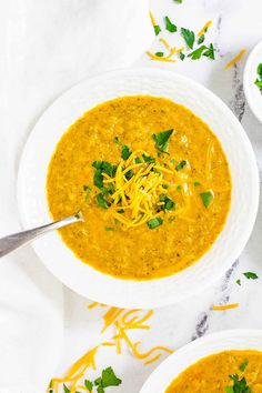 two bowls of soup with cheese and parsley