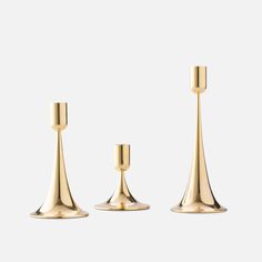 three gold candlesticks on a white background