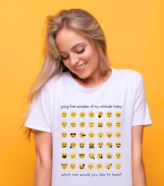 a woman wearing a white t - shirt with yellow emoticions on it