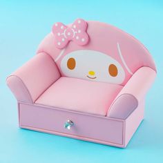 a pink toy chair with a hello kitty face on it's head, sitting in front of a blue background