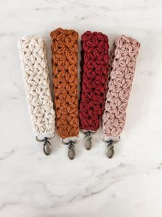 four crochet key fobs on a marble surface