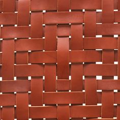 a close up view of a woven basket weave pattern in red leather, with white stitching on the edges