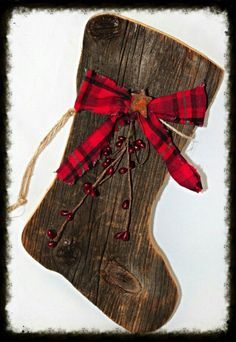 a wooden stocking with red and black plaid ribbon