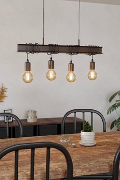 a wooden table with four lights hanging from it