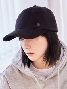 a young woman wearing a black hat with the letter d on it's side