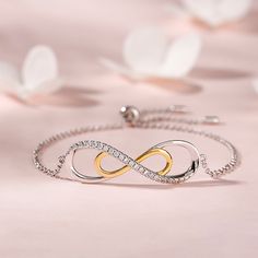 A brilliant way to show her your love is forever, this dainty bracelet will certainly touch her heart. Crafted in sterling silver, this bracelet features a sparking infinity symbol and a gold tone infinity symbol. This elegant bracelet makes a stunning statement of everlasting love. A great anytime choice, this fashion bracelet is sure to become an instant favorite.Carat Weight: 1.95 ctStone Size: 1.5 mmNumber of Stones: 26 Stone Shape: RoundStone Color: Diamond WhiteWeight: 4.2 gWidth: 42.4 mmH Elegant White Gold Friendship Bracelets, Elegant Infinity Jewelry For Friendship, Elegant Silver Jewelry For Friendship, Elegant Bracelets With Adjustable Chain For Anniversary, Elegant Adjustable Chain Bracelets For Anniversary, Elegant Adjustable Chain Bracelet For Anniversary, Dainty Infinity Jewelry For Friendship, White Gold Infinity Diamond Bracelet, Dainty Infinity Friendship Jewelry