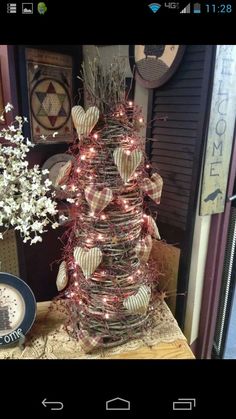 a christmas tree made out of baskets with lights on it and decorations around the base