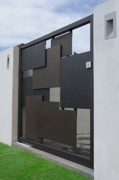 an open door on the side of a building with grass and blue sky in the background