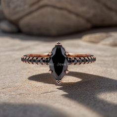 a black diamond ring sitting on top of a rock