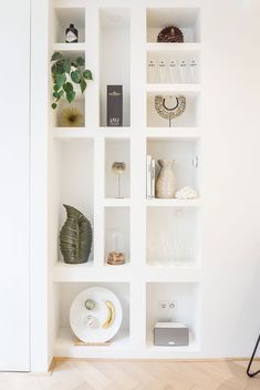 a white shelf filled with books and vases