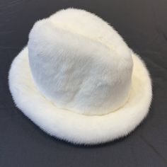 Kashani Men's White Full Mink Top HatMaterial: MinkStyle: HatColor: White Classic White Hat Bands For Winter, White Fur Felt Winter Hat, White Fur Felt Hat For Winter, White Fedora Hat For Winter, White Fedora For Winter, White Flat Brim Felt Hat For Winter, White Felt Hat With Flat Brim For Winter, White Short Brim Felt Hat For Winter, Winter White Wide Brim Fedora