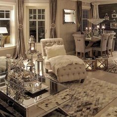 a living room filled with lots of furniture next to a table and chairs in front of a window