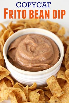 a white bowl filled with brown dip surrounded by tortilla chips