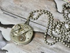 This is a vintage watch movement, just the gears. It doesn't work its just for the beauty of the inside of old watches. A conversation piece. Authentic antique/vintage pocket watch movement. Great piece for your steampunk look. I T E M ∙ S P E C I F I C A T I O N S - NECKLACE: 28" stainless steel bead ball chain - PENDANT: Watch gears are 1 1/8" round, backing is glued and makes the pendant 1 1/2" long C A R E ∙ T I P S We don’t want your special moment to fade. To maintain the quality of your j Steampunk Silver Pocket Watch With Locket, Silver Steampunk Pocket Watch With Locket, Steampunk Silver Pendant Necklace, Steampunk Silver Necklace With Round Pendant, Antique Silver Nickel-free Pocket Watch, Silver Steampunk Pendant Necklace, Silver Steampunk Necklace With Round Pendant, Antique Nickel-free Silver Pocket Watch, Silver Metal Round Pendant Pocket Watch