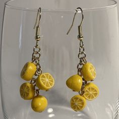 a pair of yellow lemons hanging from earrings