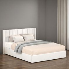 a white bed sitting on top of a hard wood floor