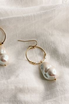 The Shelby Pearl and Gold Mini Hoop Dangle Earrings, where classic elegance meets modern sophistication. These earrings are a testament to timeless beauty, designed to add a touch of luxury to any ensemble. Crafted with meticulous attention to detail, each earring features a small gold hoop that delicately frames the earlobe, exuding understated glamour. Suspended from the hoop is a mesmerizing pearl medallion dangle, radiating elegance with every movement. The convenient hook back closure ensur Timeless Small Hoop Earrings For Everyday Elegance, Minimalist Hoop Pearl Earrings For Formal Occasions, Classic Metal Jewelry With Pearl Drop, Formal Minimalist Hoop Pearl Earrings, Classic Hoop Pearl Drop Jewelry, Timeless Metal Hoop Earrings For Gift, Elegant Metal Hoop Earrings For Everyday, Timeless Metal Hoop Earrings As Gift, Classic Metal Drop Earrings