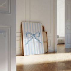 an empty room with a blue and white striped bow on the front door, framed by wood flooring