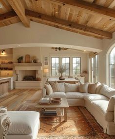 a living room filled with furniture and lots of windows next to a fire place on top of a hard wood floor