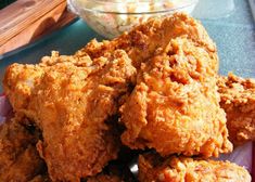 fried chicken on a plate with a bowl of ranch dressing in the backround