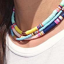 a close up of a person wearing a necklace with multicolored beads on it