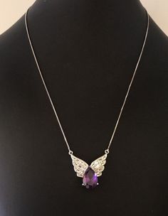 This sparking sterling silver clear rhinestone and faceted purple amethyst teardrop gemstone pendant with wings is beautiful. The pendant is 1 inch tall and 1 inch wide. It weighs 7.3 grams including the chain. It is in wonderful like new condition. The pendant hangs on a short sturdy sterling silver box chain. The clasp has some mixed metals for strength. The necklace is 20 inches long. I specialize in finding fun wearable jewelry. Please browse my shop for more options. I box jewelry ready to Silver Teardrop Amethyst Jewelry, Silver Amethyst Teardrop Jewelry, Silver Drop Amethyst Jewelry, Silver Amethyst Drop Jewelry, Silver Drop Necklace With Gemstone Accents, Silver Cubic Zirconia Briolette Jewelry, Silver Briolette Cubic Zirconia Jewelry, Elegant Silver Winged Jewelry, Silver Teardrop Jewelry With Gemstone Accents