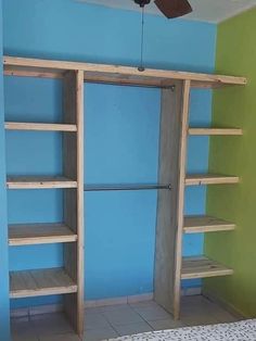 a bedroom with blue walls and wooden shelves