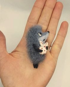 a hand is holding a tiny stuffed animal on it's palm with the finger