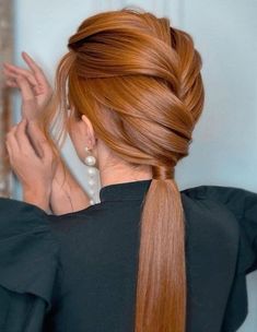 a woman with long red hair in a ponytail