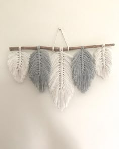 three white and grey feathers hanging on a wall