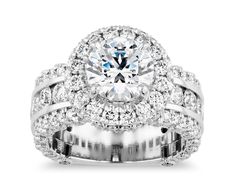 a wedding ring set with an oval center surrounded by round brilliant cut diamonds and white gold