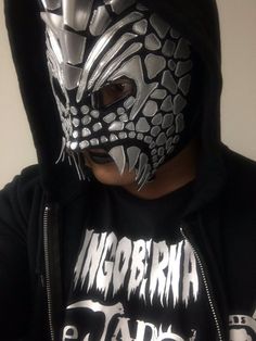 a man in a black hoodie with a silver mask on his face and hands