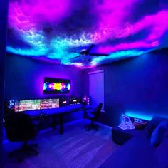 a living room filled with lots of furniture and colorful lights on the ceiling above it