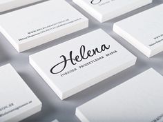 business cards with the name helena written on them in black and white letters, all stacked together