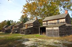 several old wooden buildings in an open field