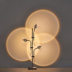 a lamp that is sitting on top of a table with three circles in the background