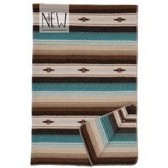 a brown and blue striped blanket on top of a white floor next to a rug