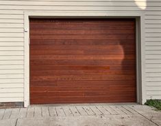 a brown garage door in front of a white house