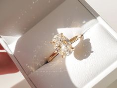 an engagement ring in a white box