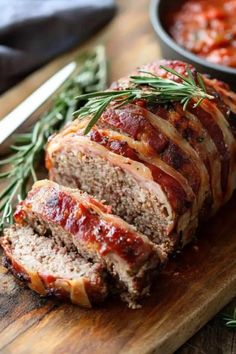 sliced meatloaf sitting on top of a wooden cutting board